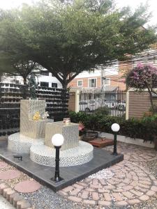 un jardín con una fuente en un patio con árboles en Smart Mansion, en Min Buri