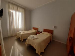 罗马Ostello Villa Monte Mario的有两张床和一扇窗户的房间