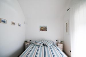 a white bedroom with a striped bed in it at Little Room - Camera indipendente nella Torre in Pontassieve