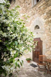 un arbusto con flores blancas delante de un edificio en Little Room - Camera indipendente nella Torre, en Pontassieve