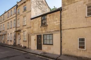 an old brick building on the side of a street at Coachman Cottage, Mews living in Central Bath in Bath