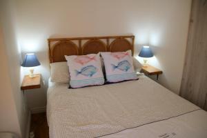 a bed with two pillows on it with two lamps at Fisherman's Watch Cottage in Cape Town