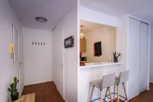 eine Küche mit zwei Stühlen und einer Theke in einem Raum in der Unterkunft TOP Cosy studio avec Terrasse à 10min Disney-Shopping Vallée in Bailly-Romainvilliers