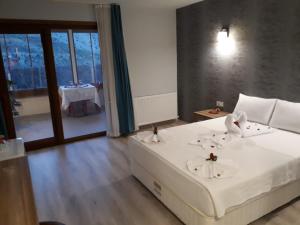 BOZKURT HOTEL في Kemaliye: غرفة نوم بسرير وملاءات بيضاء وطاولة