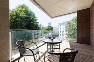 patio z 2 krzesłami i stołem na balkonie w obiekcie Central apartments, Quiet with Free Parking and AC. w Tallinnie