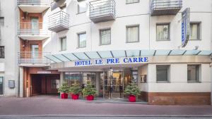 a building with potted plants in front of it at Hôtel Le Pré Carré in Annecy
