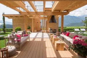 an outdoor patio with a wooden pergola and couches at Villa Grüntaler in Rodengo