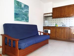 カラ・ブランカにあるApartamentos Piscisの青いソファ付きのキッチンが備わる客室です。