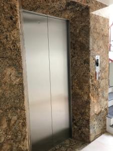 a metal elevator door in a stone wall at MAI VANG Hotel in Sapa