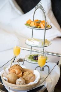 a tray of bread and fruit on a table with glasses of orange juice at Villa Grüntaler in Rodengo