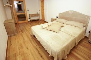 a bedroom with a large bed and a wooden floor at Cascina Bucolica B&B in Alpignano