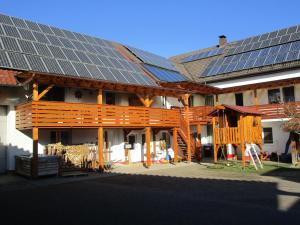 ein Gebäude mit Sonnenkollektoren auf dem Dach in der Unterkunft Ferienwohnung Sabine in Obergessertshausen