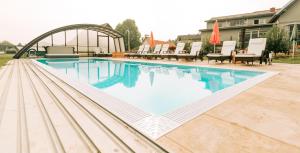 una grande piscina con sedie in cortile di Stockers kleines Dorfhotel a Deutsch Goritz
