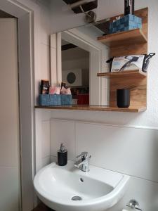 a white sink in a bathroom with a mirror at Gästeoase einfach wohl fühlen in Wolfhagen +23 photos