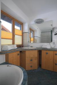 uma casa de banho com uma banheira e um espelho grande em Haus Luna em Schwangau