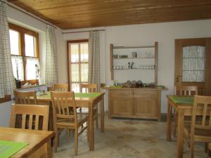 une salle à manger avec des tables et des chaises en bois dans l'établissement Pension Eva, à Neuhaus am Inn