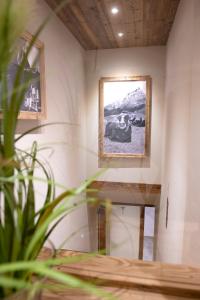 une chambre avec deux photos sur le mur et une plante dans l'établissement ArtiHome, à Hopfgarten im Brixental