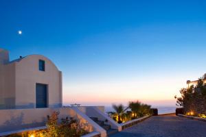 a villa with a view of the ocean at dusk at Thermes Luxury Villas And Spa in Megalochori