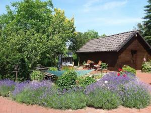 a garden with a log cabin and flowers at Ferienwohnung Hahn, 95129 in Rhauderfehn