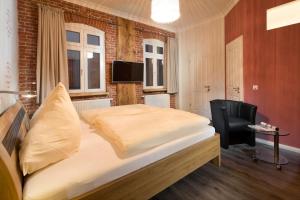 a bedroom with a bed and a chair and a television at Haus Elimar Weber in Norderney