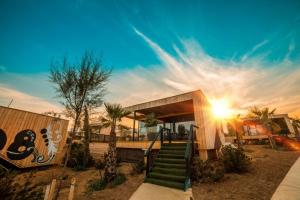 una casa con una escalera verde delante de ella en Noa Glamping Resort, en Novalja