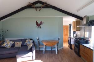 a living room with a blue couch and a table at Cosy rural self catering annex in Magherafelt