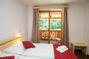 1 dormitorio con cama, ventana y silla en Bohinj Apartments Goldhorn Kingdom en Bohinj