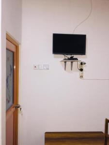 Elle comprend une télévision à écran plat suspendue sur un mur blanc. dans l'établissement Kasun Hotel, à Koslanda