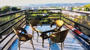 a patio with chairs and a table on a balcony at Travel Light Hotel in Puli