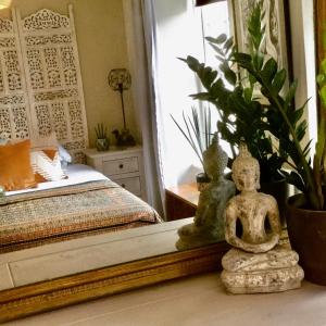 a room with a bed and a statue on a table at Bambu Cottage in Newquay