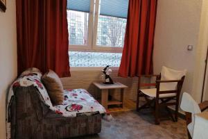 a bedroom with a bed and a window with red curtains at Oasis felix apartment in Belgrade