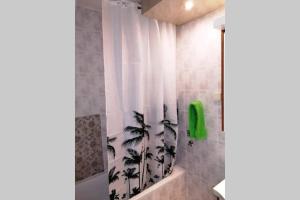 a bathroom with a shower curtain with a plant on it at Oasis felix apartment in Belgrade +23 photos