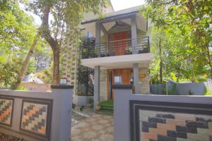 a house with a balcony in front of it at Nirrvaan homestay in Varkala
