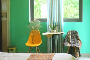 1 dormitorio con 1 cama, 1 silla y 1 ventana en Longan Homestay, en Hoi An