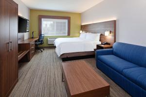 a hotel room with a bed and a couch at Holiday Inn Express & Suites - Tulare, an IHG Hotel in Tulare