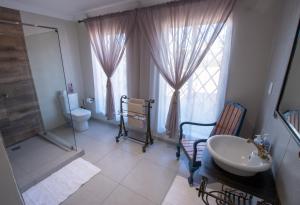 a bathroom with a sink and a toilet and a mirror at Pluvio in Parys