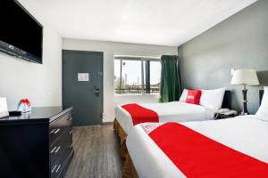 Habitación de hotel con 2 camas y TV de pantalla plana. en OYO Hotel Shreveport Airport North, en Shreveport