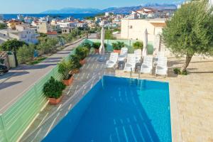 una piscina en la parte superior de un edificio con sillas y una ciudad en Villa Aleandro en Ksamil