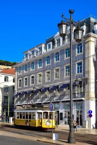 a train on the tracks in front of a building at My Story Hotel Figueira in Lisbon