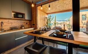 a kitchen with a wooden table and a large window at Noa Glamping Resort in Novalja