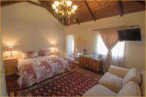 a bedroom with a bed and a couch and a chandelier at Pluvio in Parys