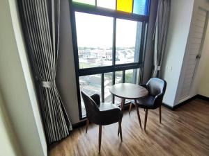 a room with a table and chairs and a large window at PS Thungsao Hotel in Hat Yai