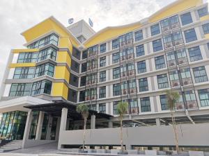 a building with palm trees in front of it at PS Thungsao Hotel in Hat Yai