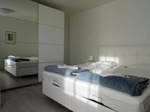 dwa łóżka w sypialni z białymi ścianami w obiekcie 204 Paris 59m2 4-8 Pers extr Bedroom w mieście Klagenfurt