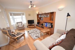a living room with a couch and a tv at Birch End, Midhurst in Midhurst