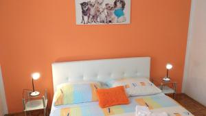 een slaapkamer met een wit bed en een oranje muur bij Jan 1 in Pula
