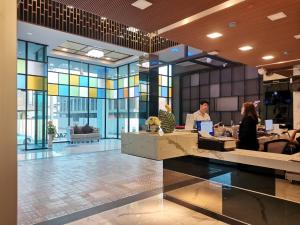 a lobby with people sitting at desks in a building at PS Thungsao Hotel in Hat Yai