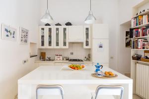 una cucina con isola bianca e cesto di frutta di Savelli Apartment a Roma