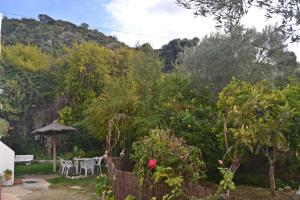 un jardín con valla, mesas y árboles en Casa La Cascada, en El Bosque
