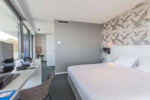 a hotel room with a large bed and a desk at Fletcher Hotel-Restaurant Het Veerse Meer in Arnemuiden
